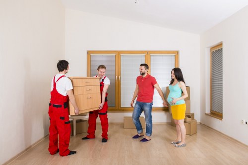 Removal team preparing a move in West Kensington street with a van and packed boxes