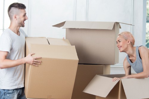 Professional movers carrying household furniture through a West Kensington property entrance